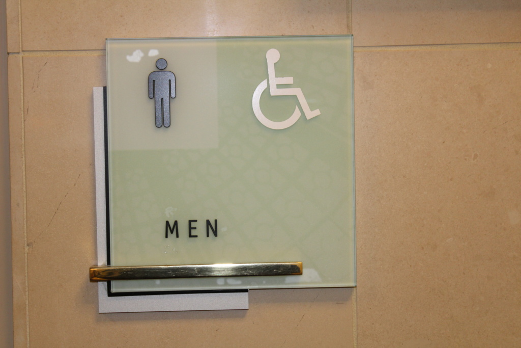 Close-up of ADA signs installed in a Kansas commercial space, demonstrating compliance with accessibility design requirements.