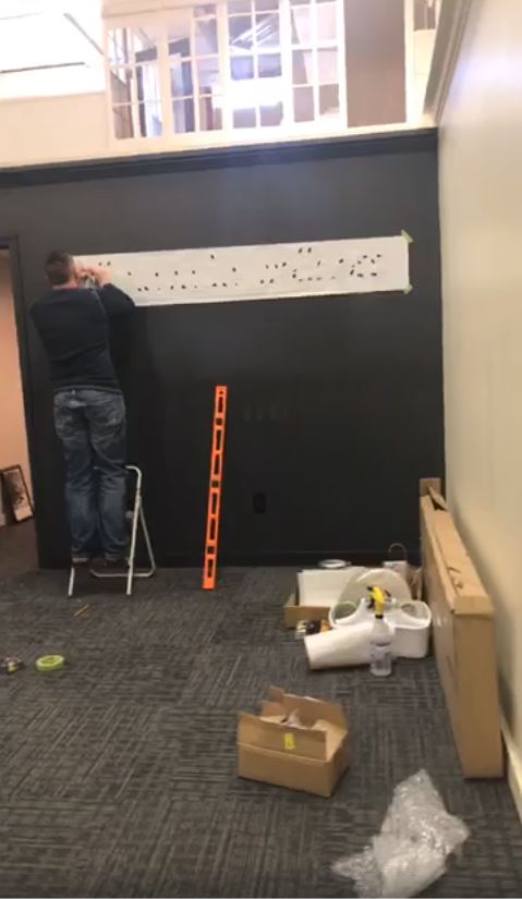 Prairie Fire Signs & Graphics installing interior signs, ensuring precise placement and professional branding for a Kansas business interior.