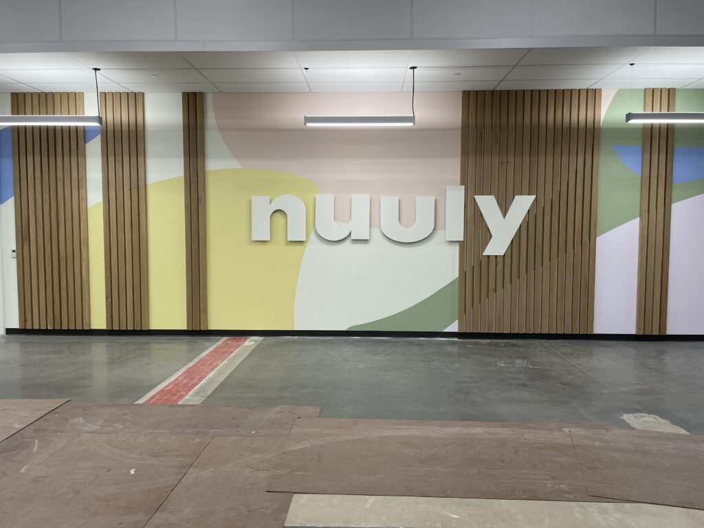 An impressive indoor sign complementing Nuuly's reception's modern aesthetics